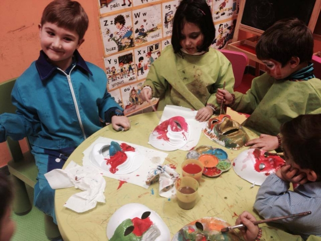  children painting masks with watercolors 